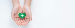 A person sealing a plastic bag with unused pills mixed with coffee grounds on a kitchen counter.