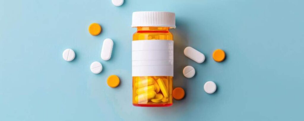 Close-up of a hand placing a pill into a weekly medication organizer on a kitchen counter.